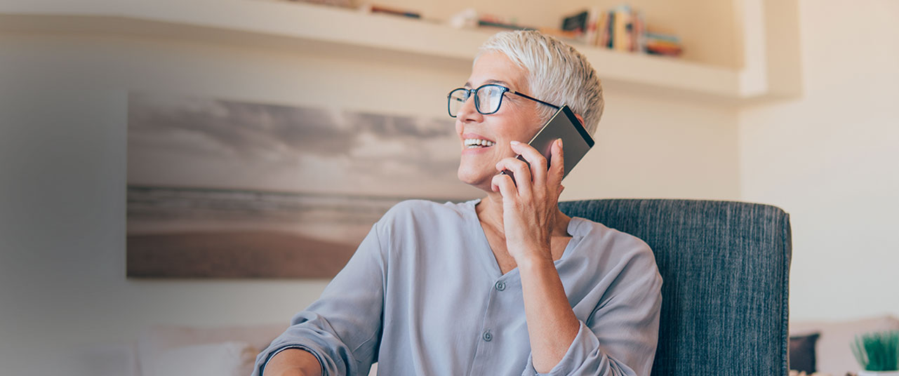 A woman talks on her phone, smiles and looks up. You can contact the Oklahoma Social Security Disability lawyers at Troutman & Troutman at their office in Tulsa.