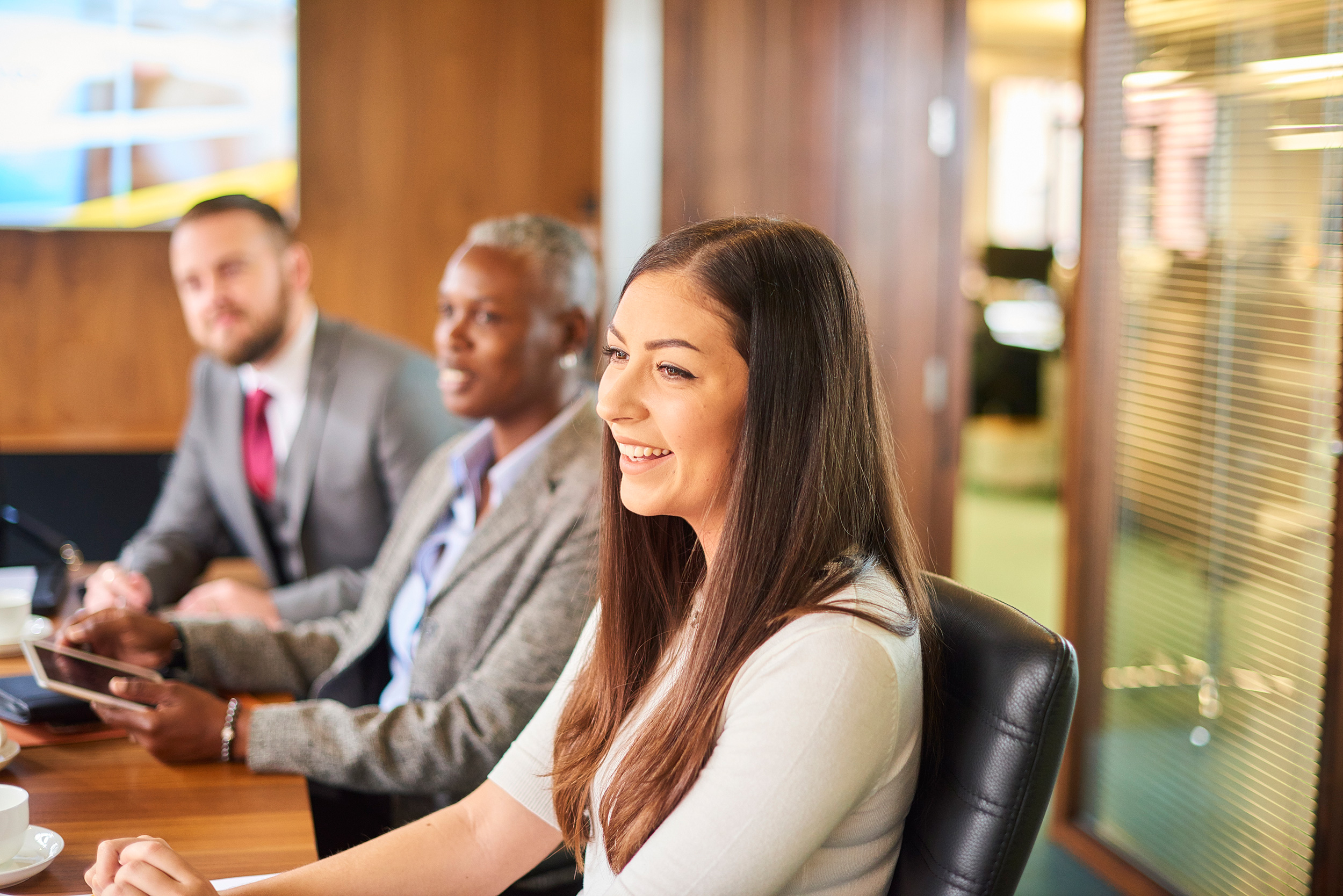 Three people in business attire, two women and a man, sit in a meeting at a conference room table. The Social Security Disability lawyers at Troutman & Troutman know how to appeal a disability benefits denial.