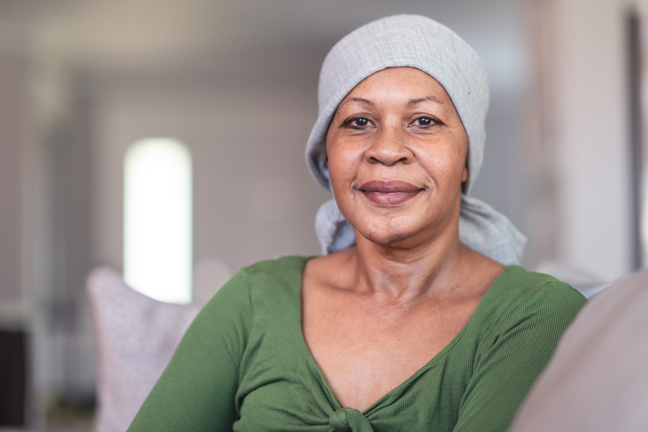 A woman wearing a head scarf sits on a couch and gently smiles. Social Security maintains a list of impairments that can qualify for disability benefits.