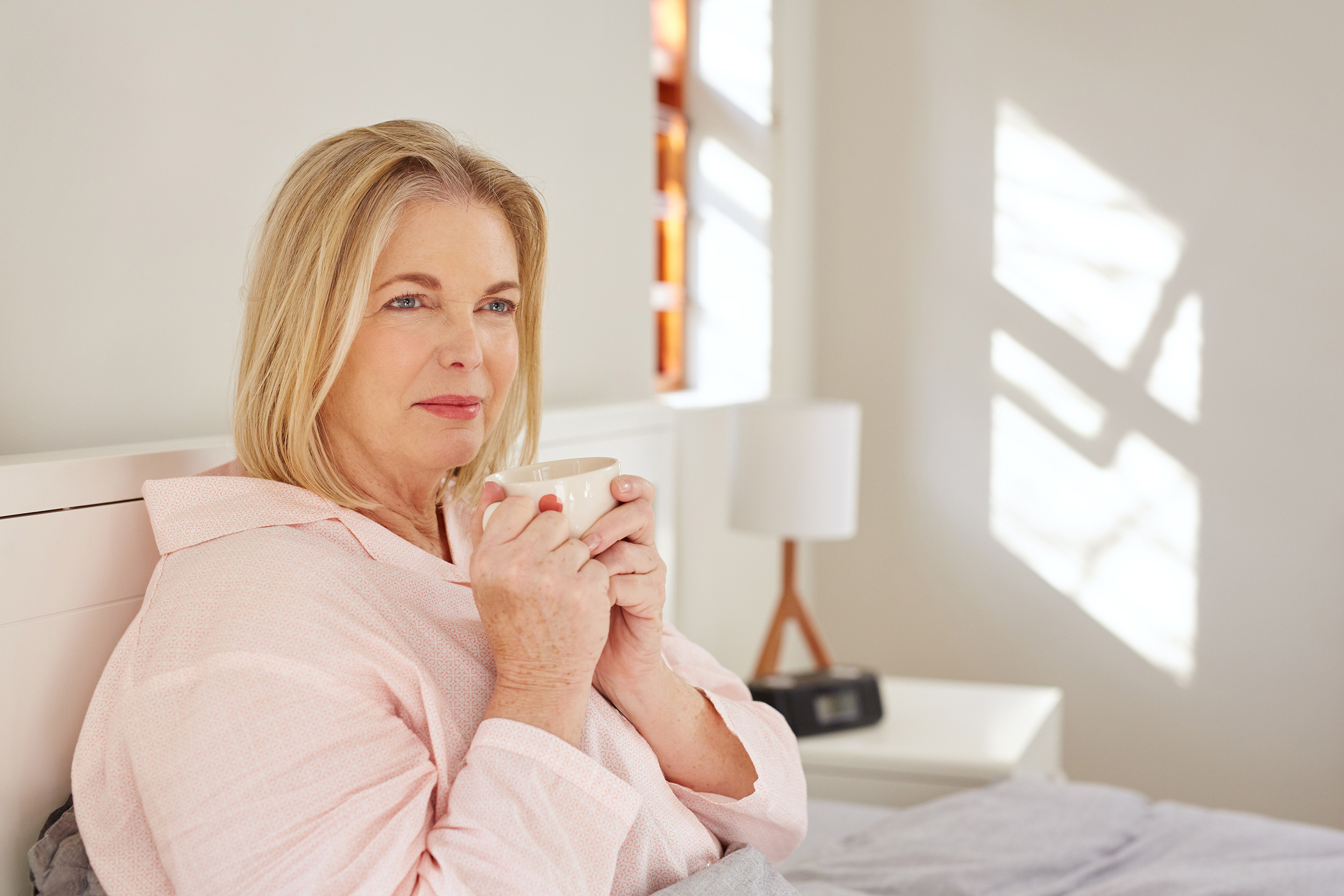 Sitting in her bed, a woman holds her coffee mug and looks up. Top reasons you may be denied Social Security Disability include health and employment situations that don't qualify for benefits.