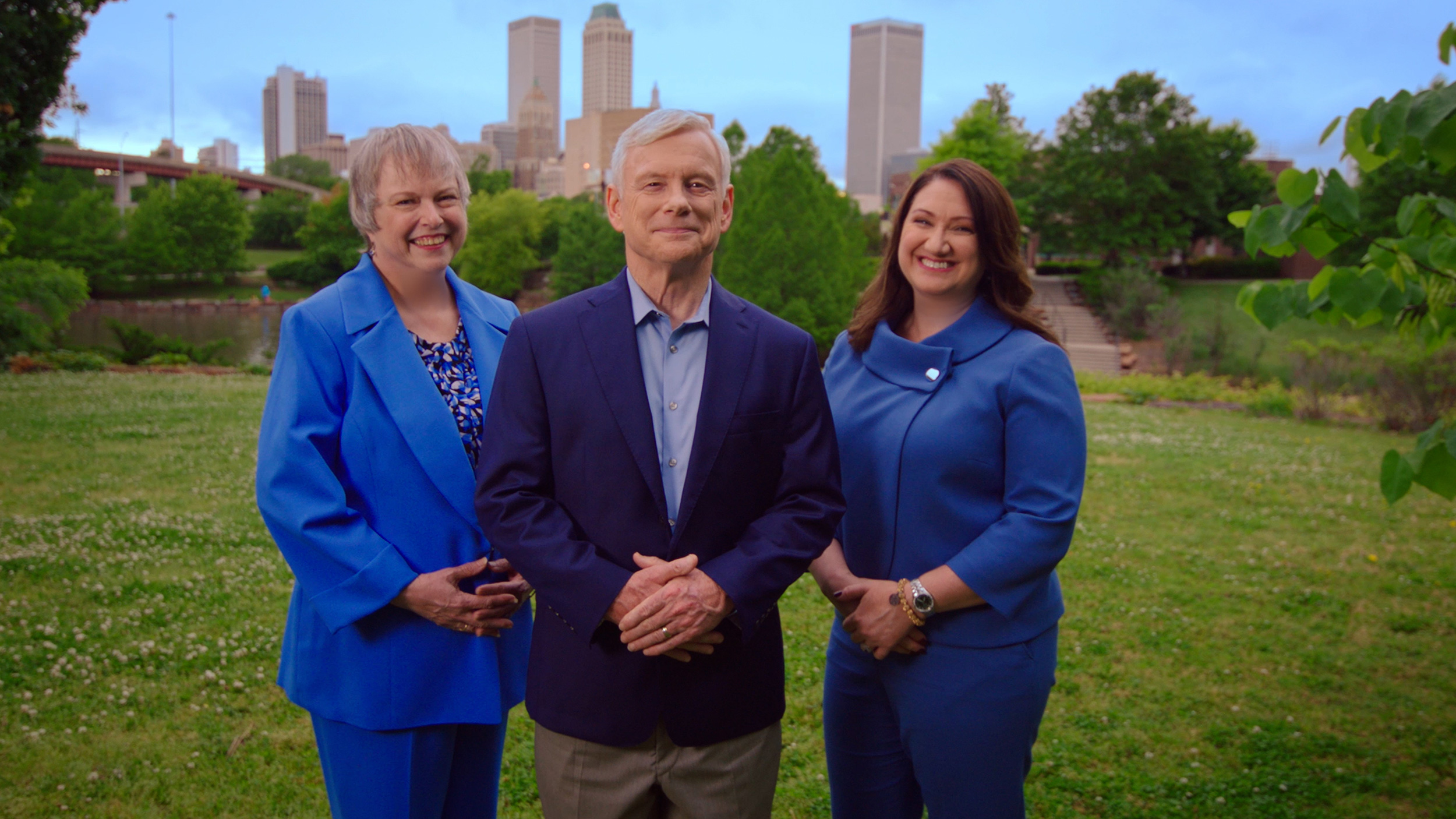 Disability lawyers Gayle Troutman, Steve Troutman and Erin Stackenwalt stand in a park with downtown Tulsa behind them.