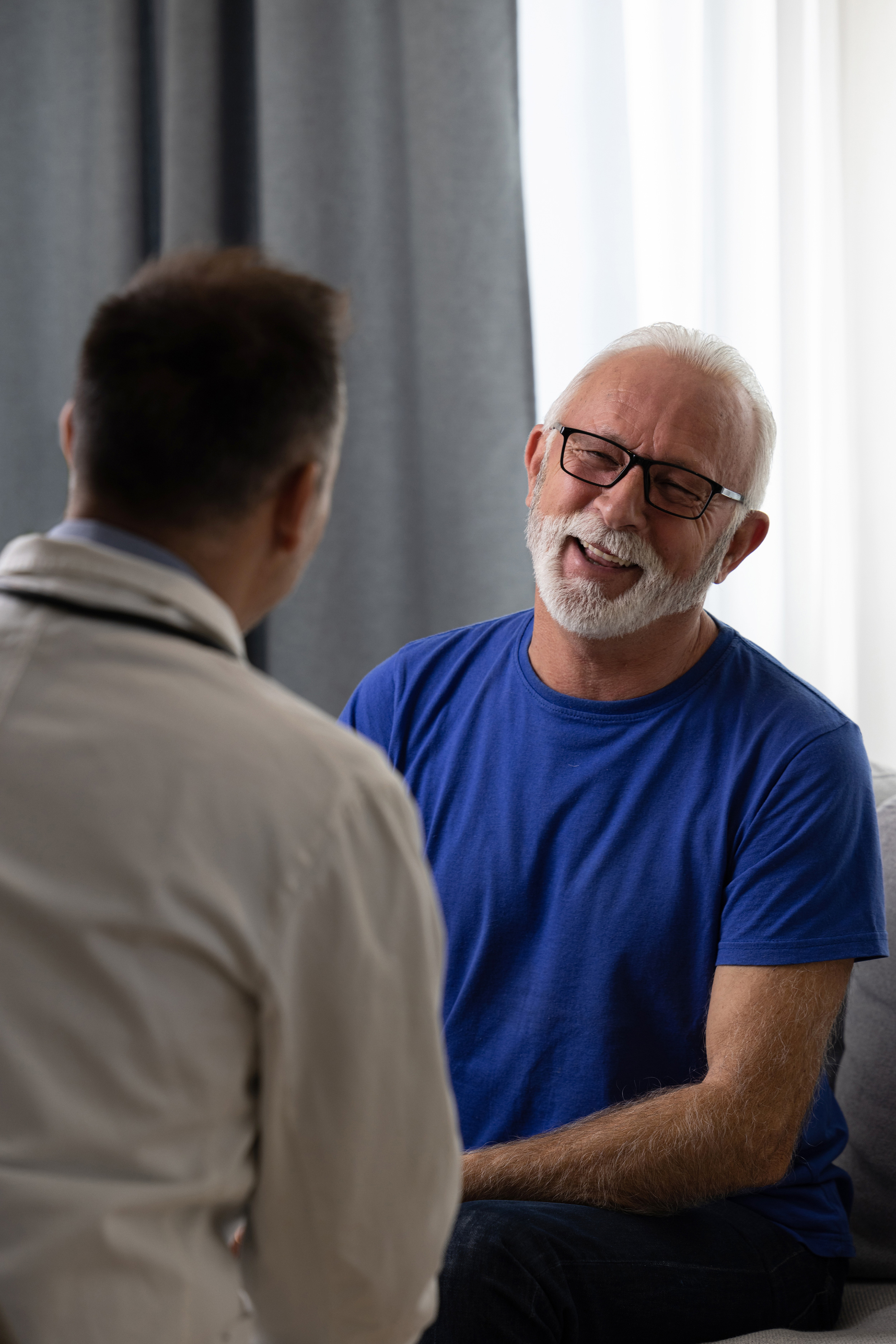 A man smiles while he talks to his doctor. With offices in Tulsa, Troutman & Troutman disability lawyers have decades of experience helping people in Bartlesville.