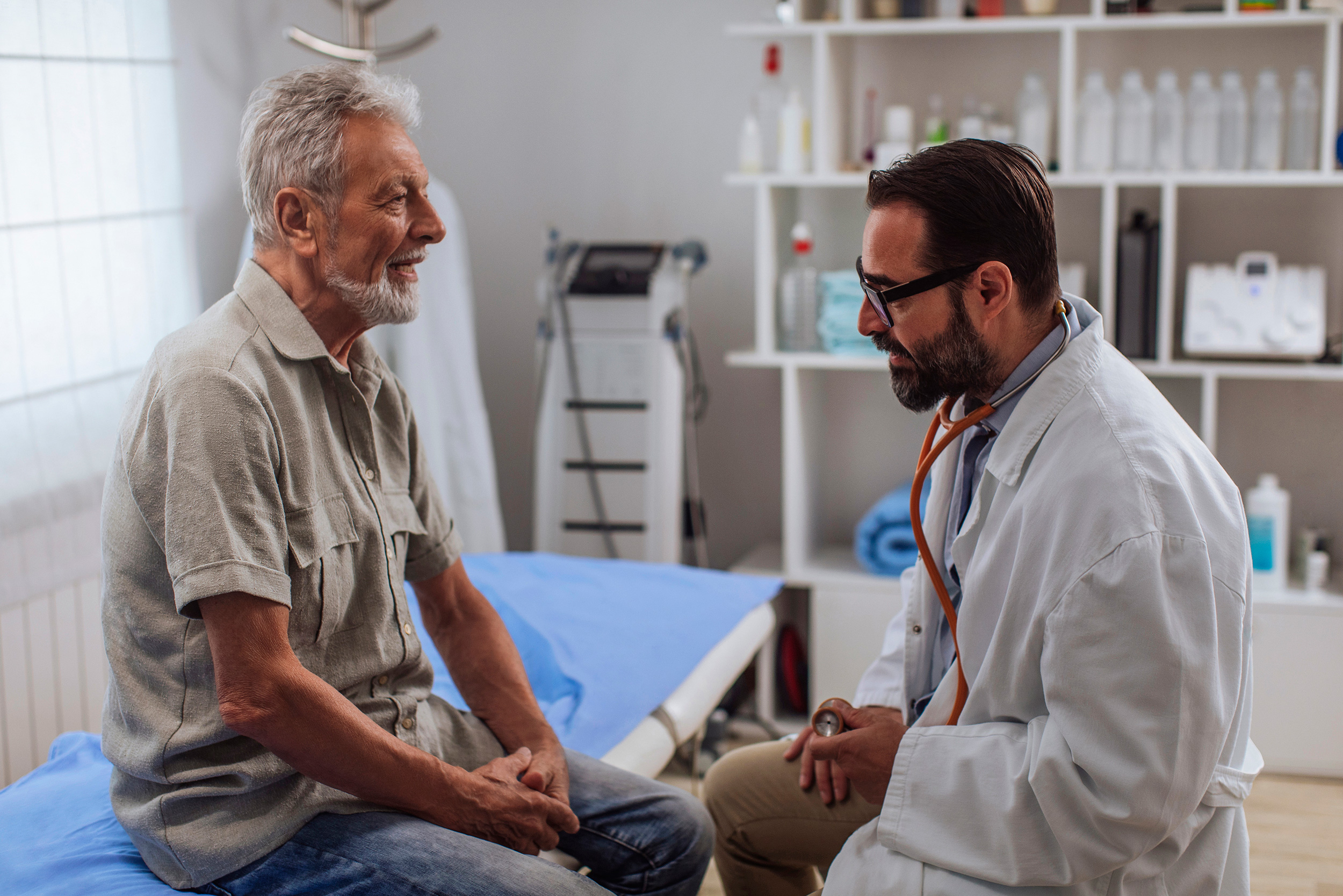 Sitting on an examining room table, a man talks to his doctor. The amount of benefits you receive are different for Supplemental Security Income (SSI) and Social Security Disability Insurance (SSDI).
